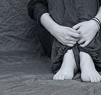 Auf dem Boden sitzender Mensch in schwarzweiß