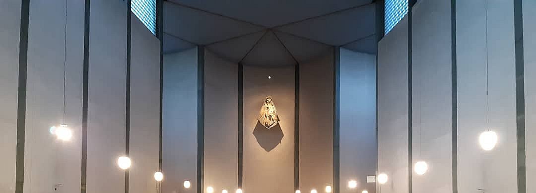 Blick in die bestuhlte Kirche mit Lichtern